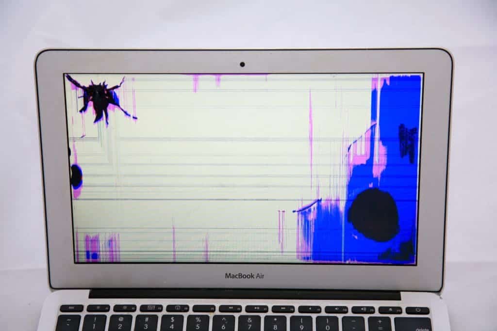 11" macBook Air with blue and pink discoloration resulting from hit to top left and bottom right of the computer