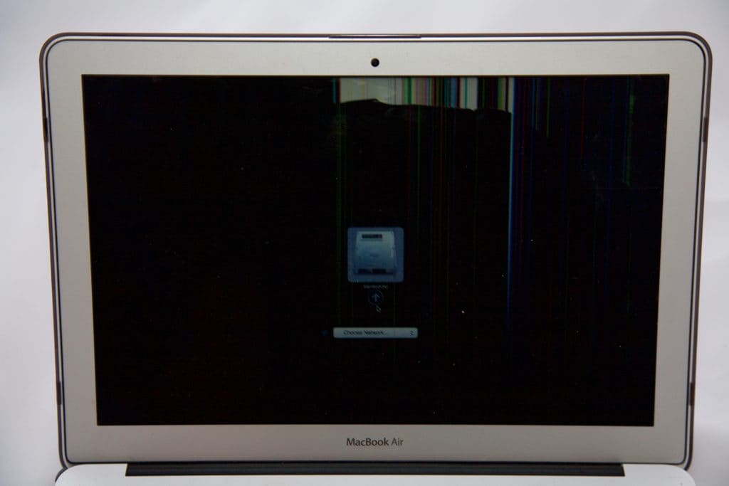 13" MacBook Air with startup drive visible on display. Top of the display you see LCD damage resulting in colored lines going about 1 inch down from the top