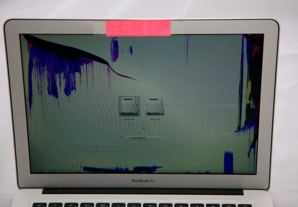 13" MacBook Air with red sticky note covering the isight camera. Display is damaged causing purple discoloration in the top left and far right of the dispaly