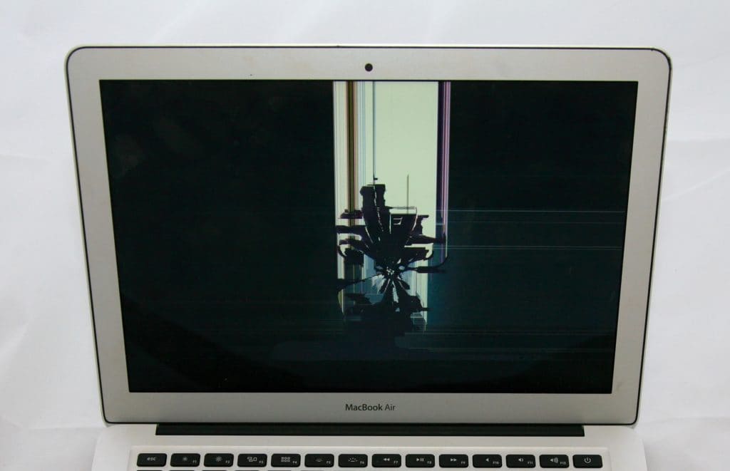 13 Inch MacBook Air with a spiderweb crack from impact to the apple logo on the back of the display.