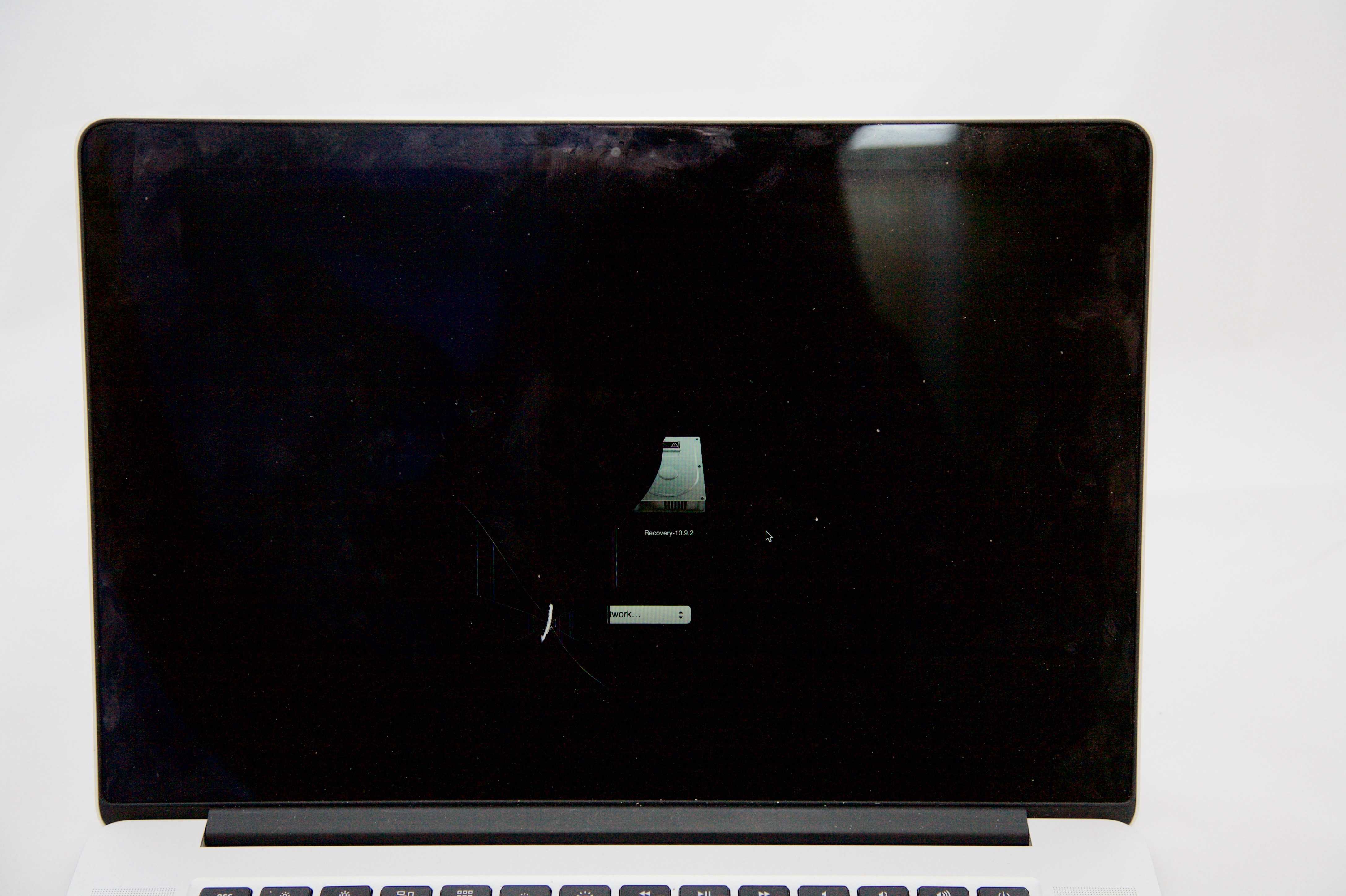 MacBook Pro Retina with half of the startup drive visible. The other half is blacked out by the crack on the screen